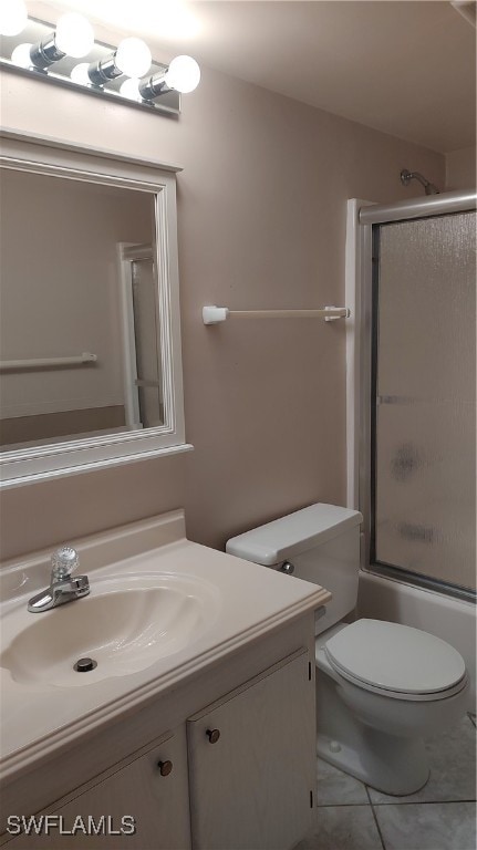 full bathroom with tile patterned floors, vanity, toilet, and combined bath / shower with glass door