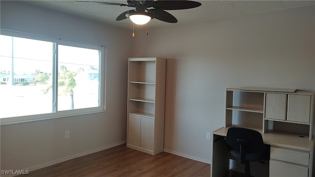 unfurnished office featuring hardwood / wood-style floors, ceiling fan, and a textured ceiling