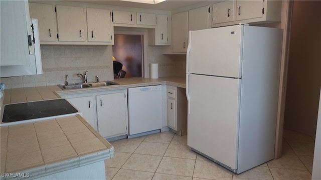 kitchen with decorative backsplash, light tile patterned floors, white appliances, and sink