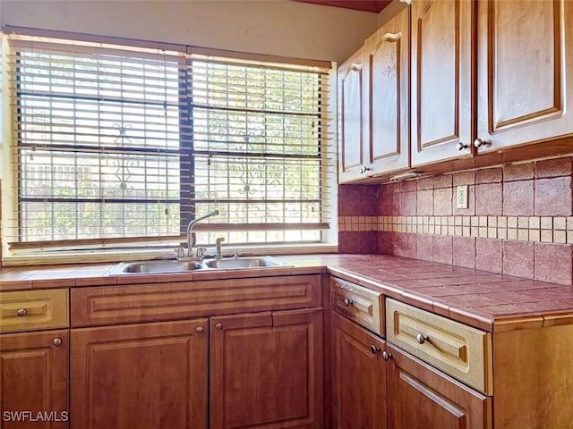 kitchen featuring tile countertops, sink, and plenty of natural light