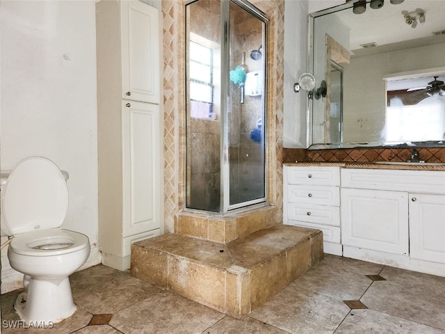 bathroom featuring ceiling fan, toilet, a shower with shower door, and vanity