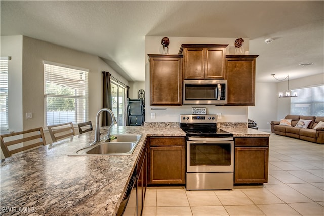 kitchen featuring light tile patterned floors, stainless steel appliances, a notable chandelier, and sink