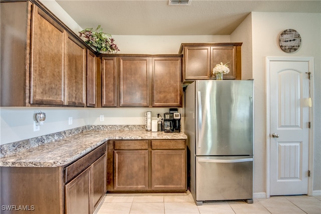 kitchen featuring stainless steel fridge and light tile patterned floors