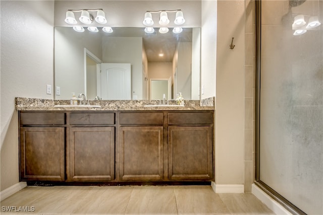 bathroom featuring tile patterned flooring, vanity, and a shower with shower door