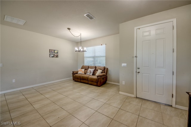 tiled entryway featuring a notable chandelier