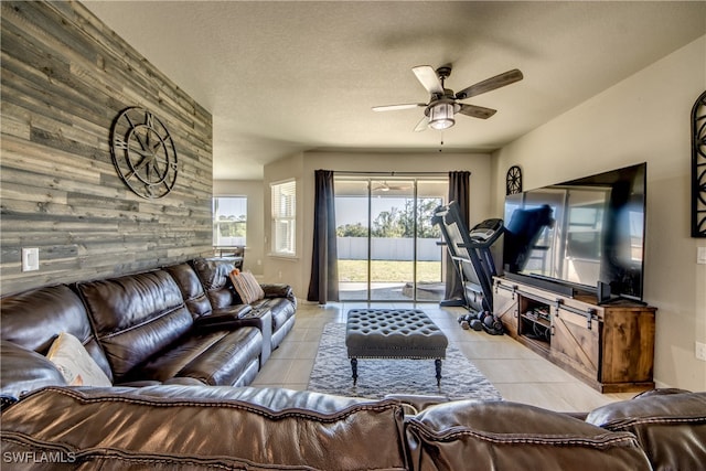 living room with ceiling fan, light tile patterned floors, and a textured ceiling