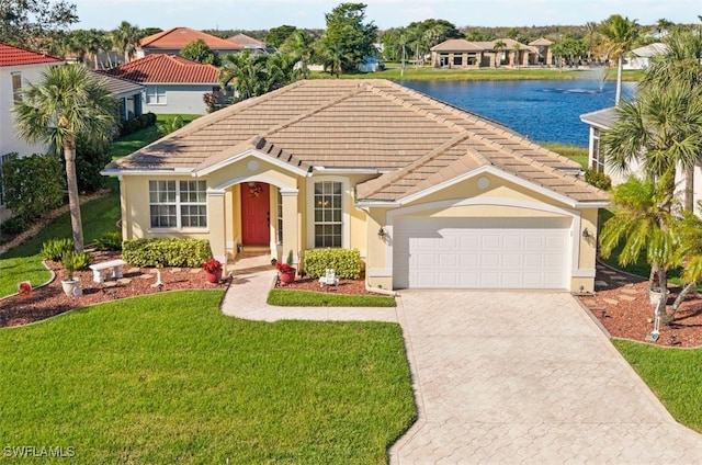 mediterranean / spanish-style home with a front lawn, a water view, and a garage