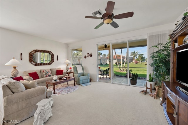 carpeted living room with ceiling fan