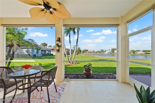 sunroom with a water view and ceiling fan