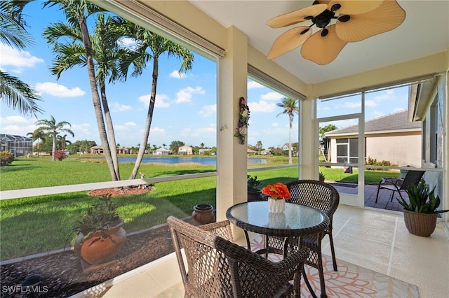 sunroom featuring a water view and ceiling fan