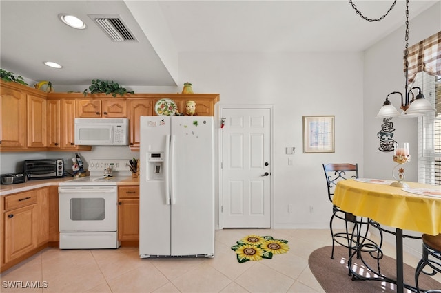 kitchen with light tile patterned floors, hanging light fixtures, white appliances, and a notable chandelier