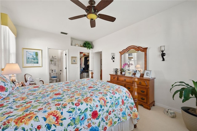 carpeted bedroom featuring ceiling fan, a closet, a walk in closet, and ensuite bath