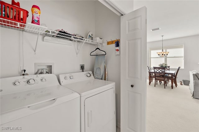 laundry room with carpet flooring, a notable chandelier, and independent washer and dryer