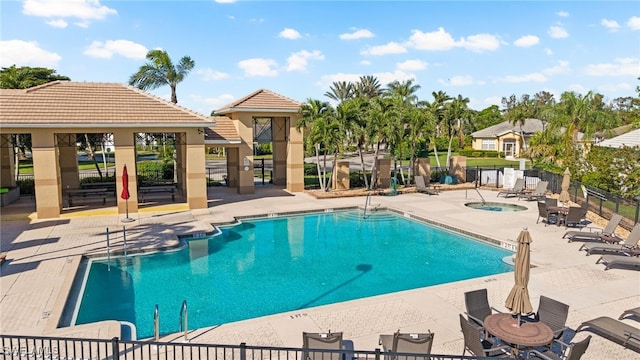 view of pool with a patio and a hot tub