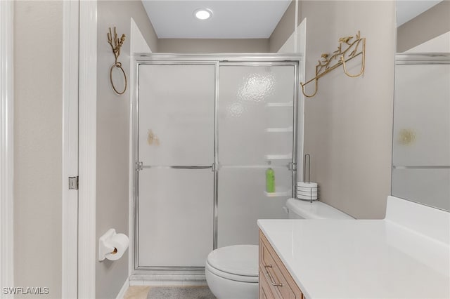 bathroom with tile patterned floors, vanity, toilet, and a shower with shower door