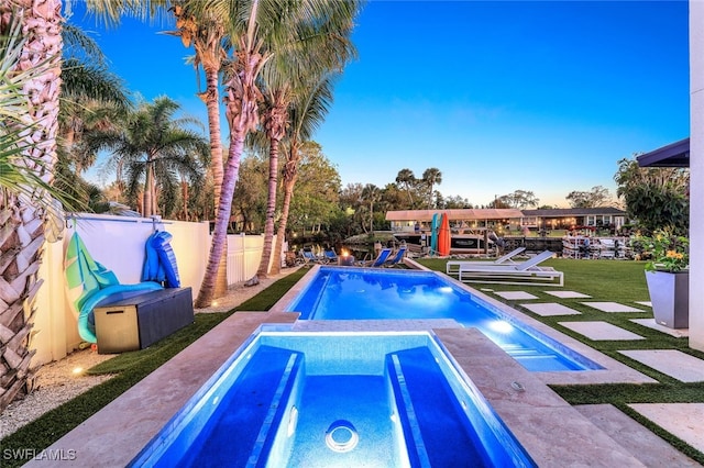 view of pool with a lawn and a dock