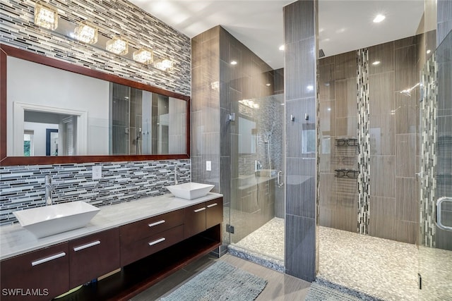 bathroom featuring walk in shower, decorative backsplash, vanity, and tile walls