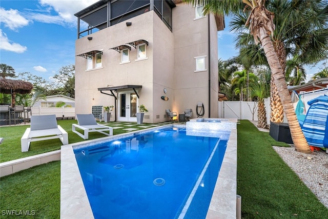 view of swimming pool with a lawn and french doors