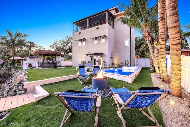 back of house with a lawn, a fenced in pool, and a balcony