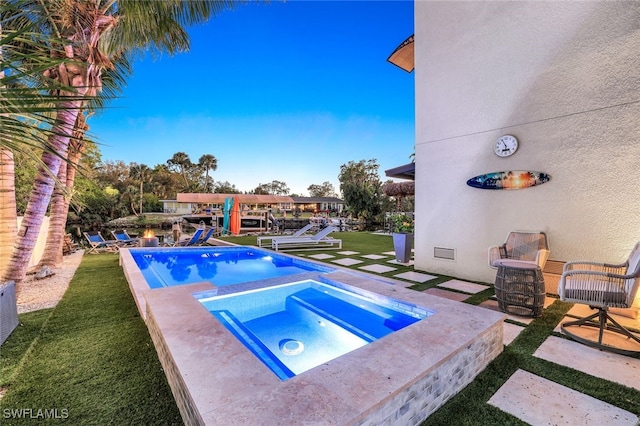 view of pool with a yard and an in ground hot tub