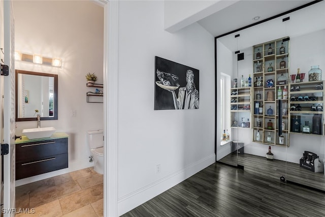 hallway with hardwood / wood-style flooring and sink