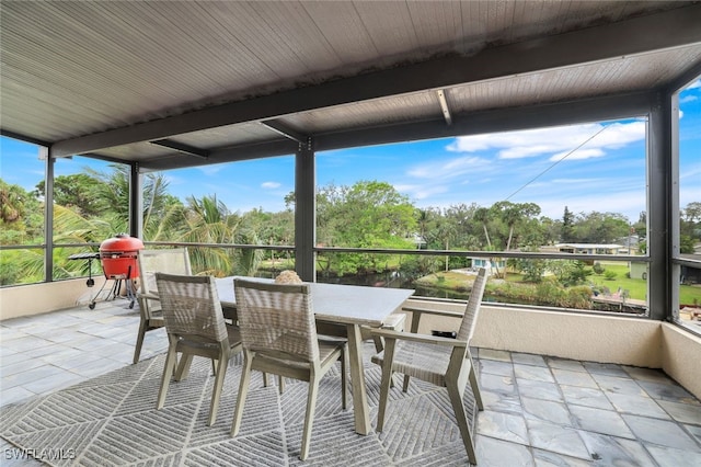 sunroom / solarium featuring beam ceiling