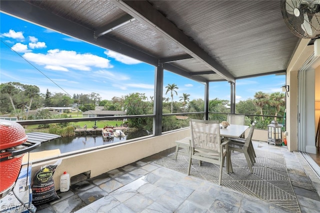 sunroom featuring a water view