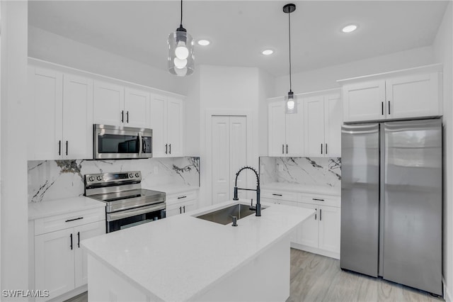 kitchen with white cabinetry, sink, decorative light fixtures, and appliances with stainless steel finishes