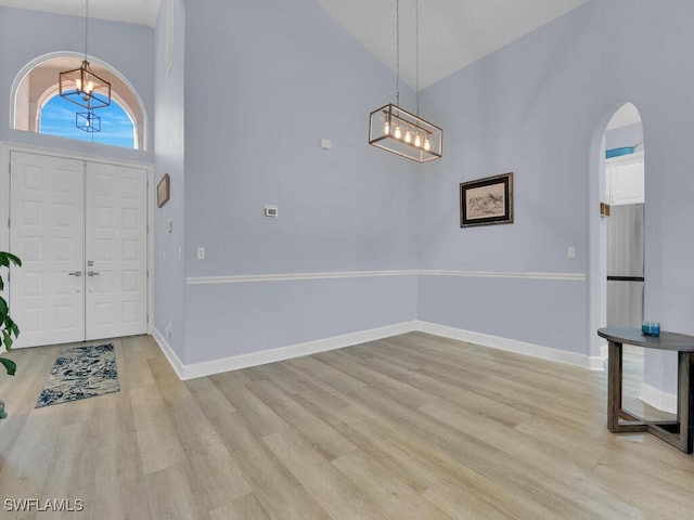 entrance foyer featuring light hardwood / wood-style floors and high vaulted ceiling