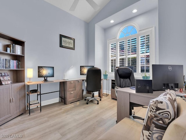 home office with ceiling fan, light hardwood / wood-style floors, and vaulted ceiling