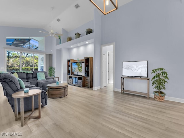 living room with ceiling fan, high vaulted ceiling, and light wood-type flooring