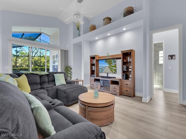 living room featuring ceiling fan, high vaulted ceiling, and light hardwood / wood-style floors