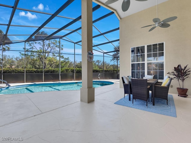 view of pool featuring a patio, glass enclosure, and ceiling fan