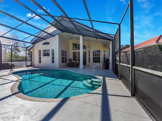 view of pool featuring ceiling fan, a patio area, and a lanai