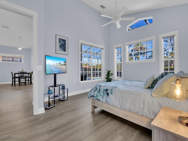 bedroom featuring ceiling fan, wood-type flooring, and high vaulted ceiling