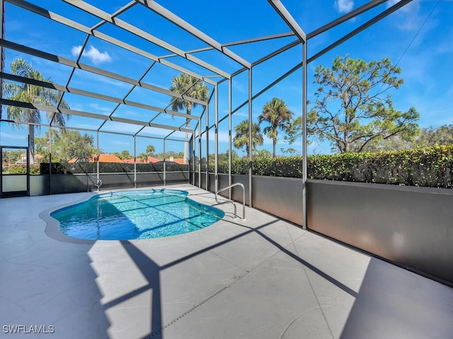 view of pool with glass enclosure and a patio