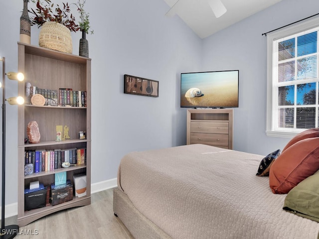 bedroom with ceiling fan, light hardwood / wood-style flooring, and lofted ceiling