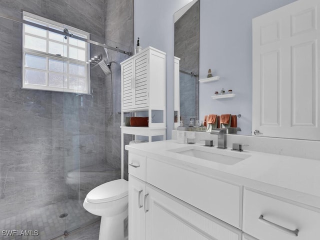 bathroom featuring vanity, an enclosed shower, and toilet