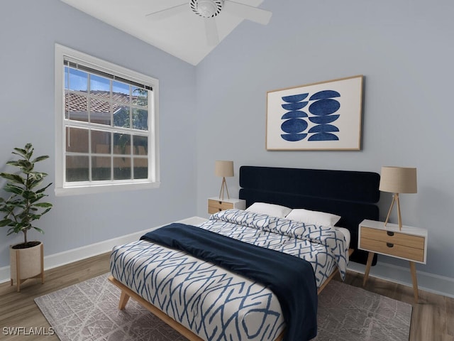 bedroom with ceiling fan, dark hardwood / wood-style floors, and vaulted ceiling