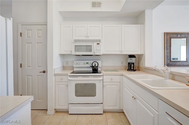 kitchen featuring white cabinetry, sink, light tile patterned floors, and white appliances