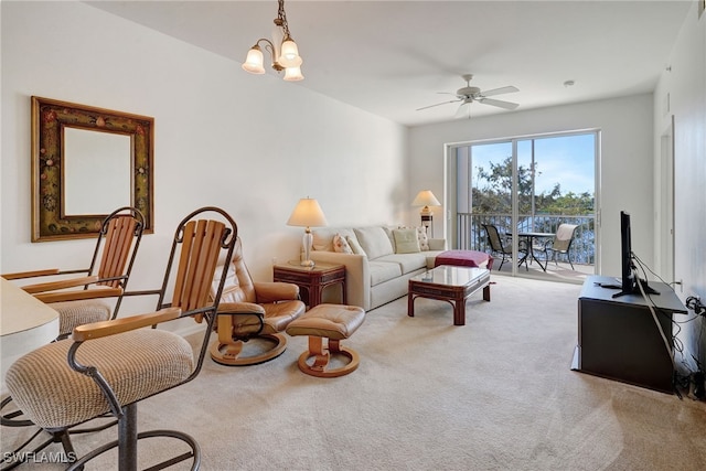 carpeted living room featuring ceiling fan with notable chandelier