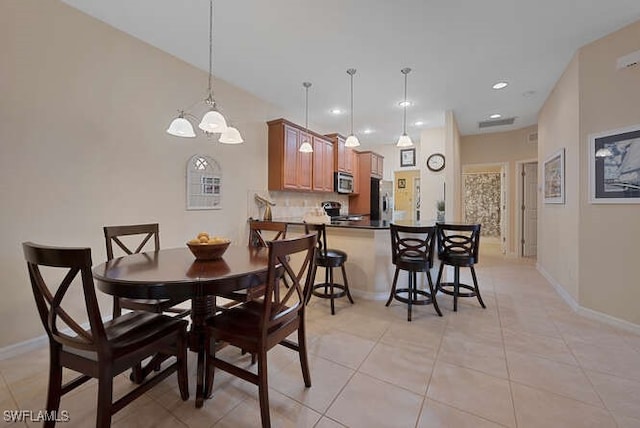 tiled dining area with a chandelier