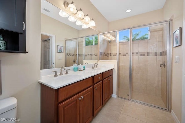 bathroom with toilet, tile patterned flooring, a shower with door, and vanity