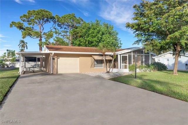 view of front of home with a sunroom, a front lawn, and a garage