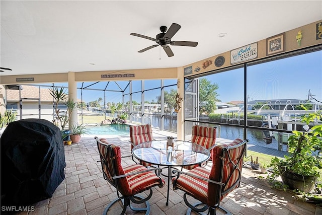 sunroom featuring a water view, a wealth of natural light, and ceiling fan