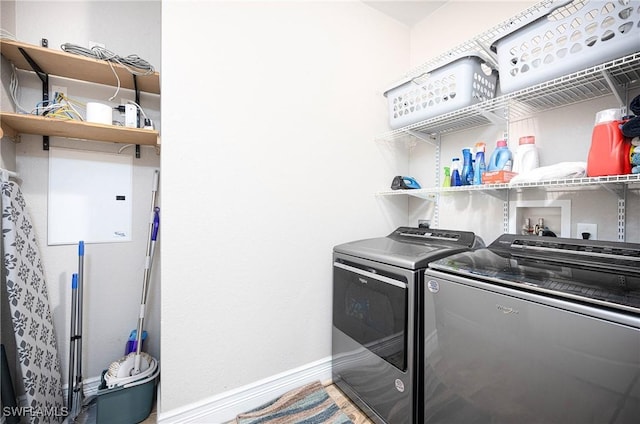 clothes washing area with separate washer and dryer