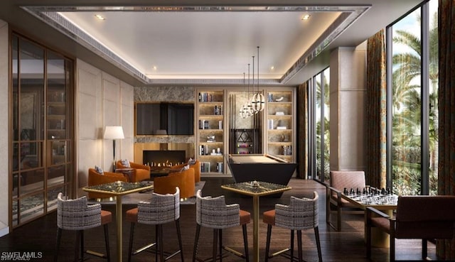 bar with a notable chandelier, a raised ceiling, dark wood-type flooring, and pool table