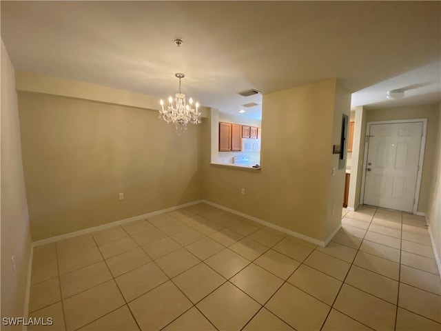 tiled empty room featuring an inviting chandelier