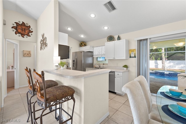 kitchen with sink, white cabinetry, light tile patterned floors, appliances with stainless steel finishes, and kitchen peninsula