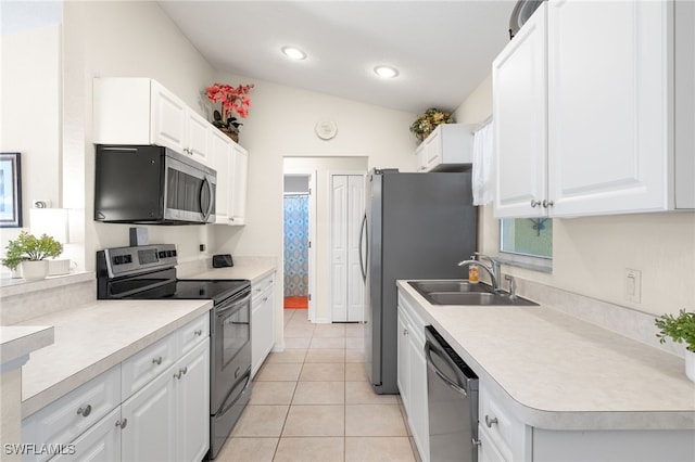 kitchen featuring lofted ceiling, appliances with stainless steel finishes, sink, and white cabinets